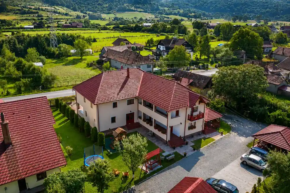 Pensiunea Casa Moldovan din Sovata văzută de sus, înconjurată de grădină și dealuri împădurite